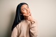 © Krakenimages.com - Young beautiful chinese woman wearing casual sweater over isolated white background Thinking worried about a question, concerned and nervous with hand on chin