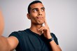 © Krakenimages.com - Young handsome african american man wearing casual t-shirt making selfie by camera serious face thinking about question, very confused idea