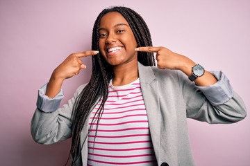 Canvas Print - Young african american business woman standing over pink isolated background smiling cheerful showing and pointing with fingers teeth and mouth. Dental health concept.