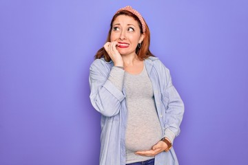 Poster - Young beautiful redhead pregnant woman expecting baby over isolated purple background looking stressed and nervous with hands on mouth biting nails. Anxiety problem.