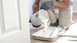 © RightFramePhotoVideo - Professional interior construction worker pouring white color paint to tray.