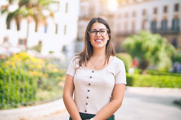 Wall Mural - Young beautiful woman smiling happy and confident. Standing with smile on face at the town street