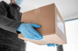 © Maridav - Home delivery shopping box man wearing gloves and protective mask delivering packages at door.