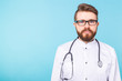 © satura_ - Bearded doctor standing with stethoscope over blue background with copy space. Medicine, healthcare and people concept.
