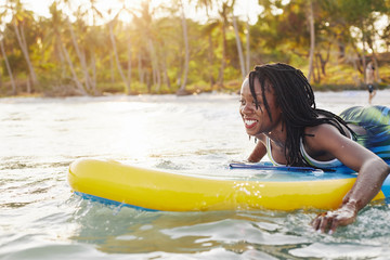 Wall Mural - Joyful excited young woman surfing in the ocean