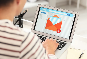 Canvas Print - Young man with laptop checking his e-mail at home