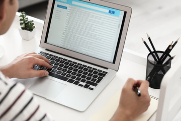 Canvas Print - Young man with laptop checking his e-mail at home