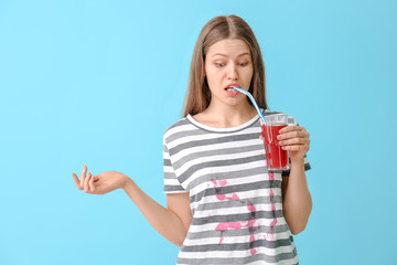 Canvas Print - Woman in dirty clothes drinking juice on color background