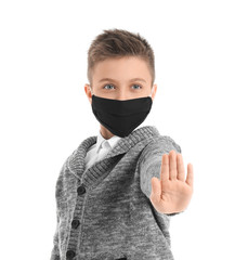 Sticker - Little schoolboy in protective mask showing stop gesture on white background. Concept of epidemic