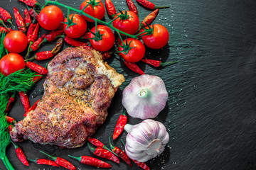 Juicy piece of grilled meat with tomato, garlic and pepper