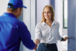 © DragonImages - Smiling beautiful young woman opening entrance door and greeting repairman