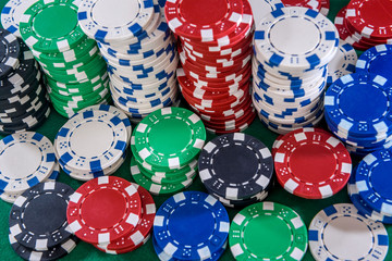 Colorful casino chips on green felt table close up. Gambling concept. Playing poker and other gambling games