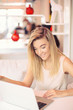 © Denys - a beautiful young smiling businesswoman is   working   on a laptop in a cosy cafe  in the morning