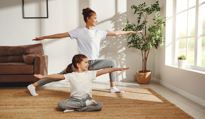 Mother and daughter practicing yoga at home.