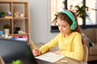 © Syda Productions - children, education and distant learning concept - student girl in headphones doing school test at home