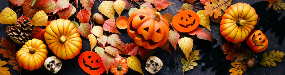 pumpkins with halloween decorations on dark background