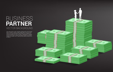 Silhouette of businessman and businesswoman handshake on top of bank stack . Concept of t business partnership and cooperation.