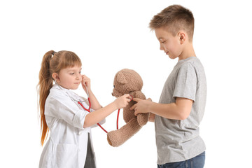 Poster - Cute little doctor with boy and teddy bear on white background