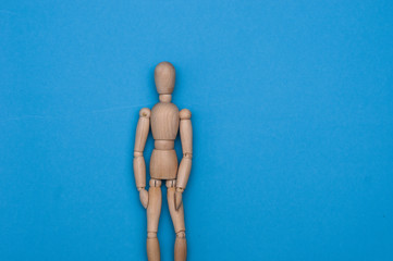 Wooden dummy with hands on hips on grey backgroundToilet paper and wooden man on yellow background, space for text