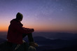 Silhouette of young traveler sitting and watched the star and milky way on the Himalayas mountain Nepal.. He is happy to be with herself and stay with nature.