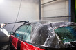 © velimir - washing a red car convertible manually by brush with foam.