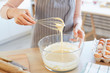 © Seventyfour - Unrecognizable woman making dough for cupcakes using whip, horizontal high angle shot