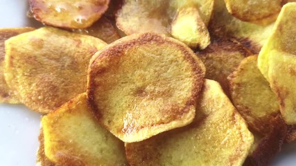 Sticker - Potato chips fried in oil on a white plate.