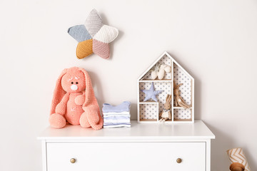 Wall Mural - Chest of drawers with clothes and toys in children's room