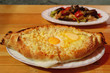 Adjaruli Khachapuri, a Traditional Georgian Cheese and Egg Bread on the Table with Blurry Eggplant Salad in Background
