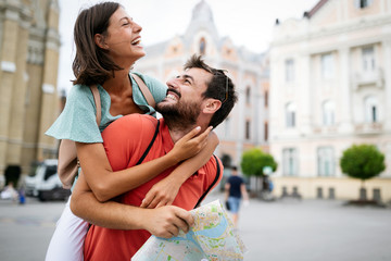 summer holidays, dating and tourism concept. smiling couple walking with map in the city