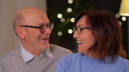 Wall Mural - relationships, old age and people concept - portrait of happy smiling senior couple at home in evening