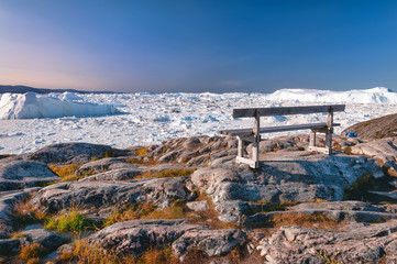 The lonely bench on the hiking trail to Sermermiut, Greenland. Sermermiut was an Inuit settlement near the town of Ilulissat, in the Disko Bay. Here, in front of the Icefjord stay this famous bench