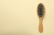 Hair brush on beige background, space for text