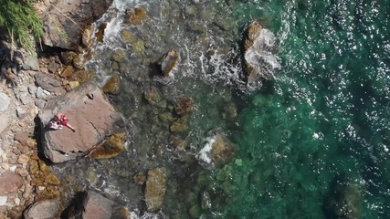 Sticker - Top down view  of rocky paradise beach, couple of tourists is sitting and look at distace. coastline of the village of Nerano. Wild beach of Italy. Turquoise, blue surface of the water. Vacation and t