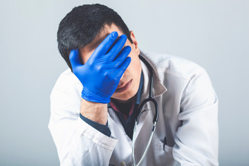 doctor holds his head in his hands