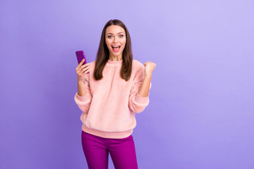 Poster - Photo of pretty addicted blogger lady holding telephone celebrating big number of new followers wear casual fur fluffy pullover pants isolated purple color background