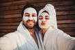 © ClaudiK - Close up selfie of beautiful happy couple after shower with a towel on head sending air kiss with cream mask on face.Woman with clay mask taking selfie with mobile phone at home enjoying relaxation.