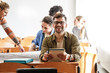 © BalanceFormCreative - Portrait of a young male university student taking a test in a classroom. Educational concept.