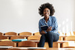 © BalanceFormCreative - In the university classroom, a portrait of determined black female student sits alone, absorbed in her test, showcasing her academic prowess and dedication to her studies.