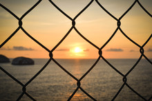 View Of Chain Link Fence At Sunset