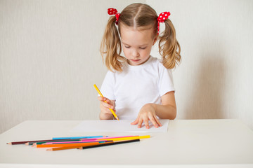 Little girl draws with crayons. Home schooling. Hobby.