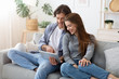 © Prostock-studio - Man and woman sitting on sofa at home, using tablet