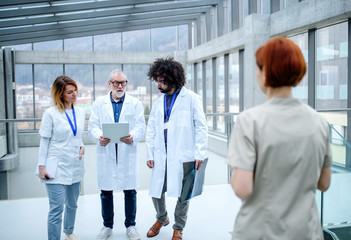 Group of doctors with tablet on conference, medical team talking.