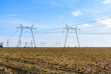 High voltage power line in a field on autumn