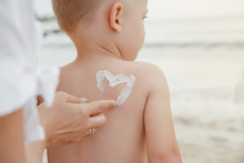 A Protective Cream On A Baby. Mother Lubricates Her Son With Cream On Vacation Near The Sea.