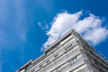 New residential building with scaffold with blue sky in the background