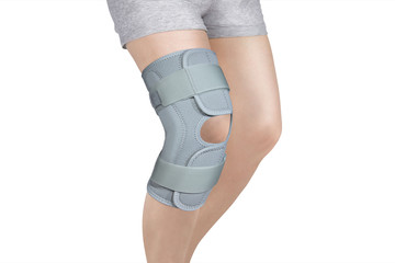 Knee Support Brace on leg isolated on white background. Orthopedic Anatomic Orthosis. Braces for knee fixation, injuries and pain. Orthotics. Foot orthosis. Knee Joint Bandage Sleeve. Elastic Sports