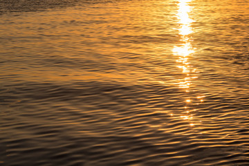 Sunset reflection on water. sparkly shiny on the surface.  Golden beams on the tranquil surface of the Caribbean sea