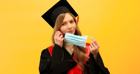 Wall Mural - Happy graduate in a master's dress, on a yellow background. Concept of the graduation ceremony