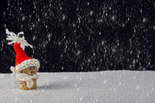 Close-up Of Figurine With Santa Hat On Snowfield At Night